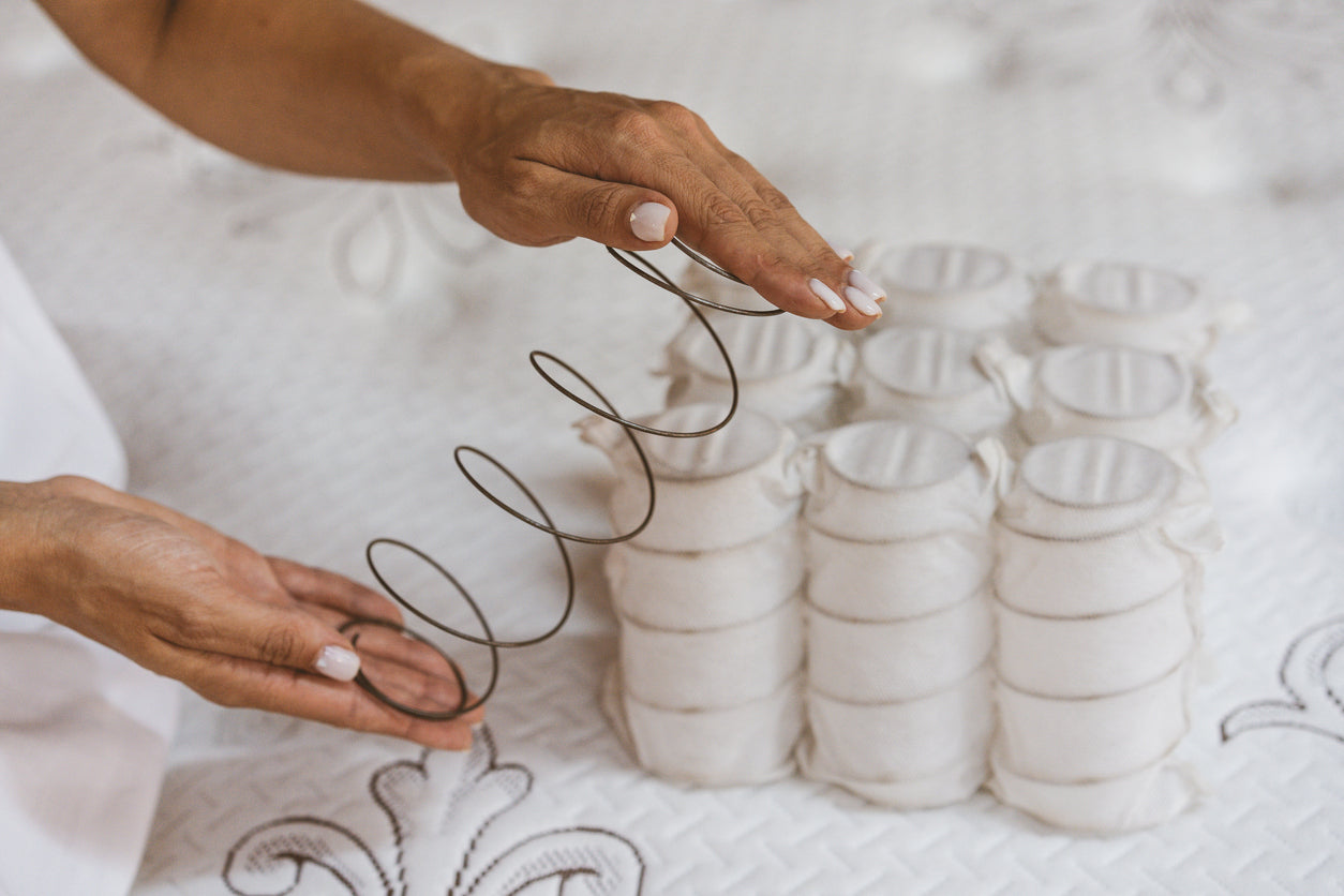 person testing pocket springs on a mattress