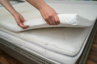 lifting up a mattress topper off a bed